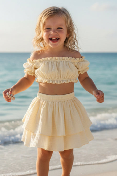 Girl wearing the yellow Hawaii Ruffle Set, off-shoulder frill crop top and tiered ruffle skirt, close-up, sizes 1-8 years | Bali Bubs