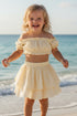 Girl wearing the yellow Hawaii Ruffle Set, off-shoulder frill crop top and tiered ruffle skirt, close-up, sizes 1-8 years | Bali Bubs