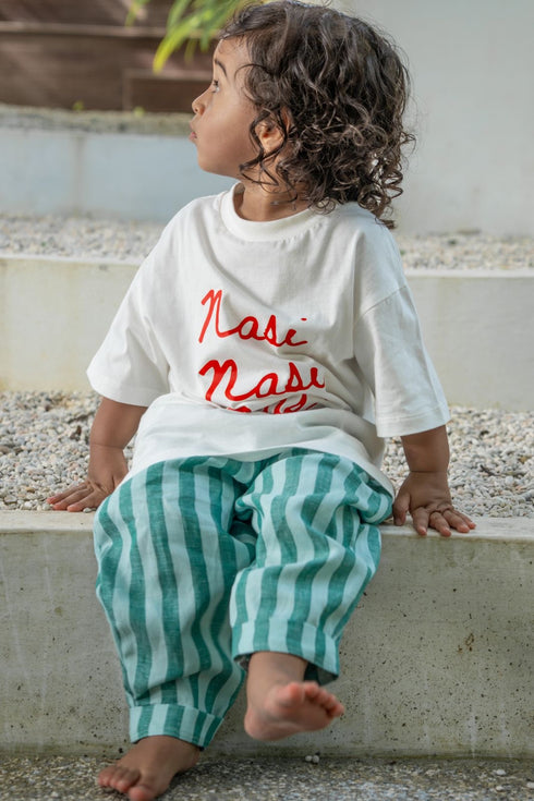 Nasi kids tee in white shirt with red text and green striped linen pants made by eco kids brand.