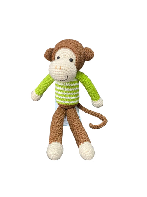 Crocheted monkey toy in a green sweater on a white background.