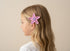 Child with pink starfish hair clip on a beige background