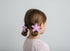 Child with star-shaped hair clips in a bun against a plain background