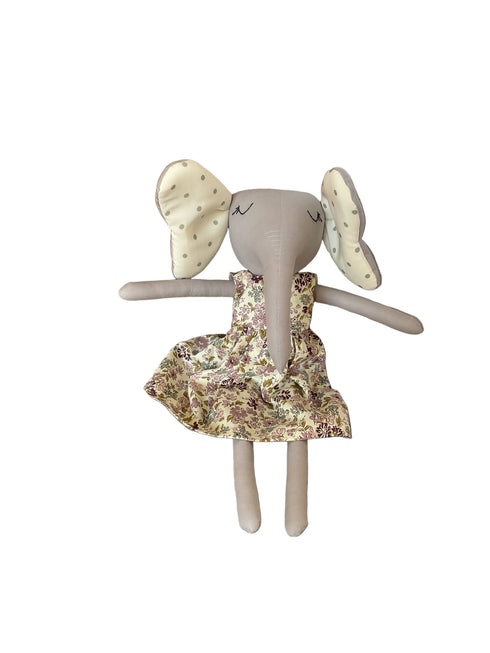 A handmade plush bunny toy with long gray limbs and embroidered eyes, wearing a floral dress.