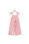 Pink jumpsuit with bow straps on a hanger against a white background