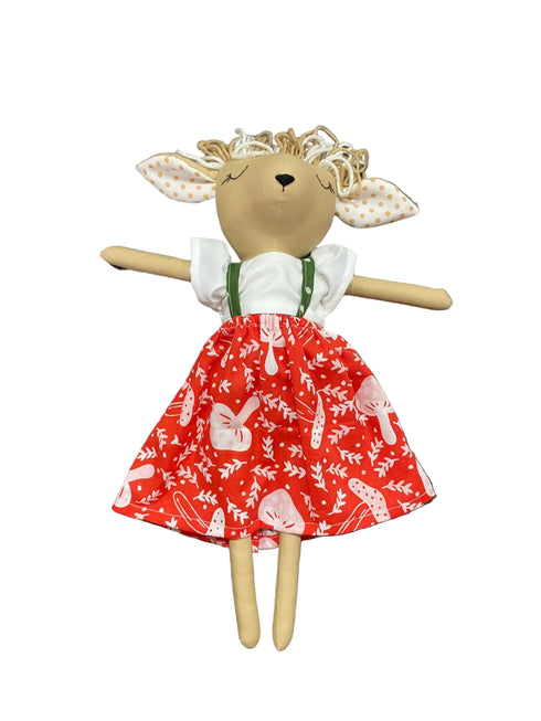 Toy deer in a red dress with white patterns on a white background