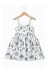 White dress with green plant pattern on a hanger against a white background