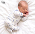 A sleeping newborn baby wearing a white footed sleeper with a blue fish pattern