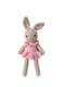 A crocheted stuffed bunny doll with long tan ears, a pink dress, and a small pink bow