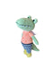 Crocheted frog toy wearing a peach shirt and striped pants on a wooden floor.