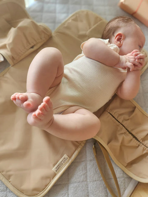 Baby lying on a beige mat with a soft focus background