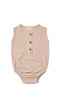A sleeveless baby romper in a light dusty pink or beige linen-like fabric, featuring a three-button henley neckline and elasticized leg openings
