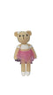 Crocheted teddy bear in a pink dress on a white surface
