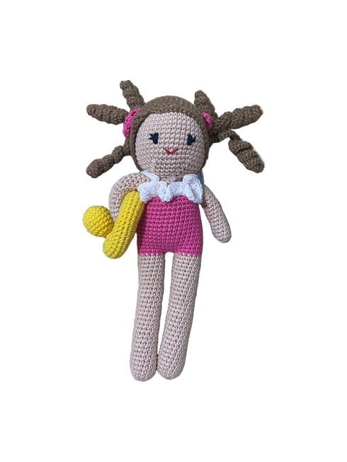 Crocheted doll with braided hair, pink top, and yellow shorts on a white background