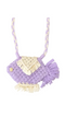 A handmade crocheted fish-shaped bag in lavender purple and cream, featuring a braided shoulder strap, cream fringe detail