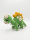 A crocheted plush dinosaur toy in green with yellow spikes