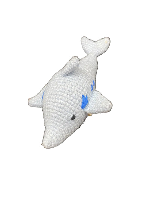 Crocheted dolphin toy on a textured surface