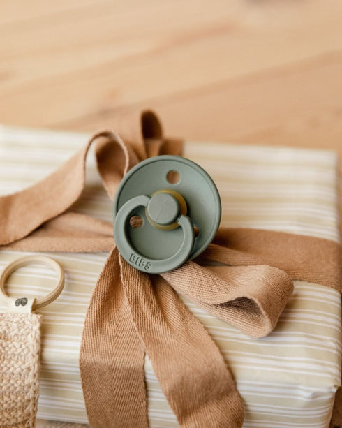 BIBS Colour pacifier in Sage tied to a gift with a ribbon