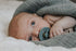 Newborn baby resting with a BIBS Colour pacifier in Sage