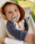 Baby in a high chair with a BIBS pacifier in Ivory