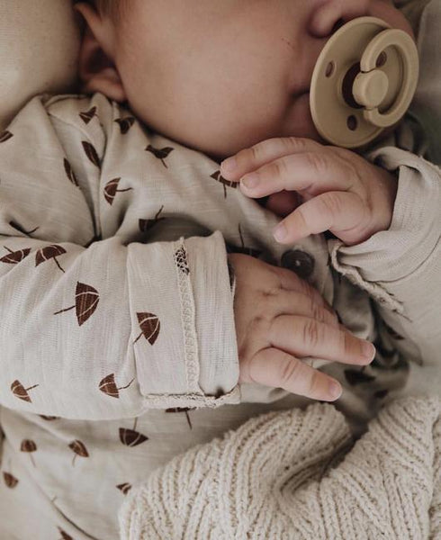 Sleeping baby with a BIBS Colour pacifier in a neutral earthy tone