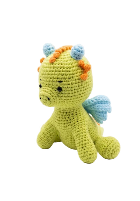 A crocheted dragon toy in light green, featuring light blue wings, blue and orange hair spikes, and small black embroidered eyes