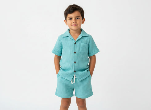 Child wearing a light blue outfit with buttons on a white background