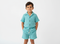 Child wearing a light blue outfit with buttons on a white background