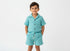 Child wearing a light blue outfit with buttons on a white background