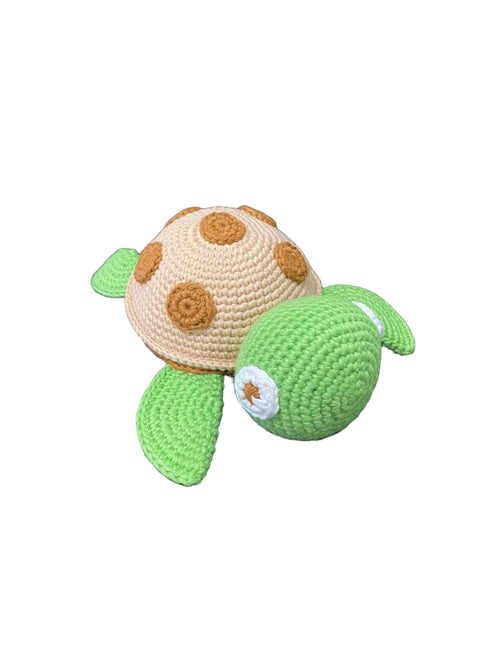 Crocheted turtle toy on a dark textured surface