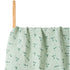 Green fabric with floral pattern on a wooden stick against a white background