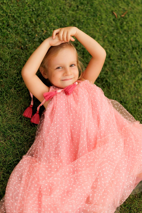 pink tulle dress with white polka dots and a bow at the neckline.