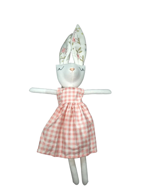 A white rabbit doll wearing a pink and white gingham dress.