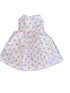 White dress with pink polka dots on a white surface