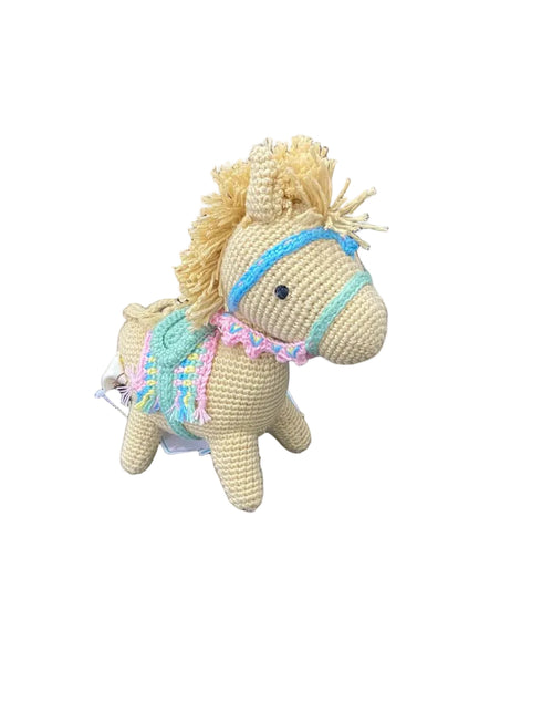 Crocheted toy horse with a colorful bridle on a white background