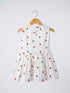 White dress with red strawberry pattern on a hanger against a white background