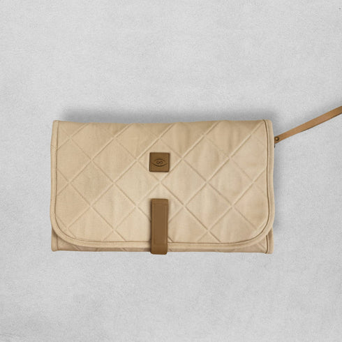 Beige quilted clutch bag with brown accents on a light gray background