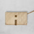 Beige quilted clutch bag with brown accents on a light gray background