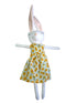 A white plush bunny doll with long pink inner ears, wearing a sleeveless dress with a yellow sunflower.