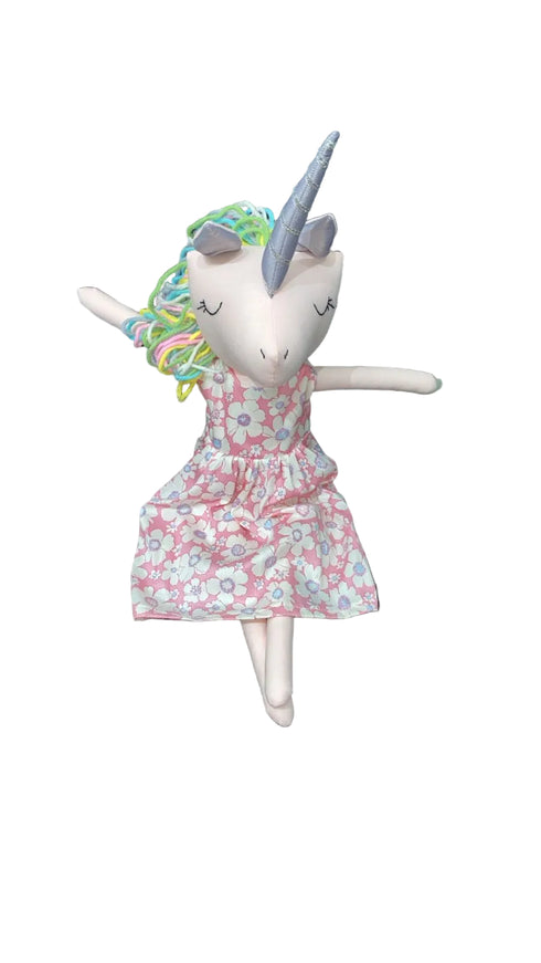 Stuffed toy with unicorn horn and floral dress on a chair