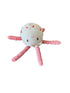 Crocheted pink creature on a gray surface with wooden slats in the background