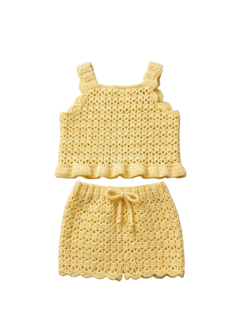 Yellow crochet baby top and shorts set on a beige surface with a neutral background.