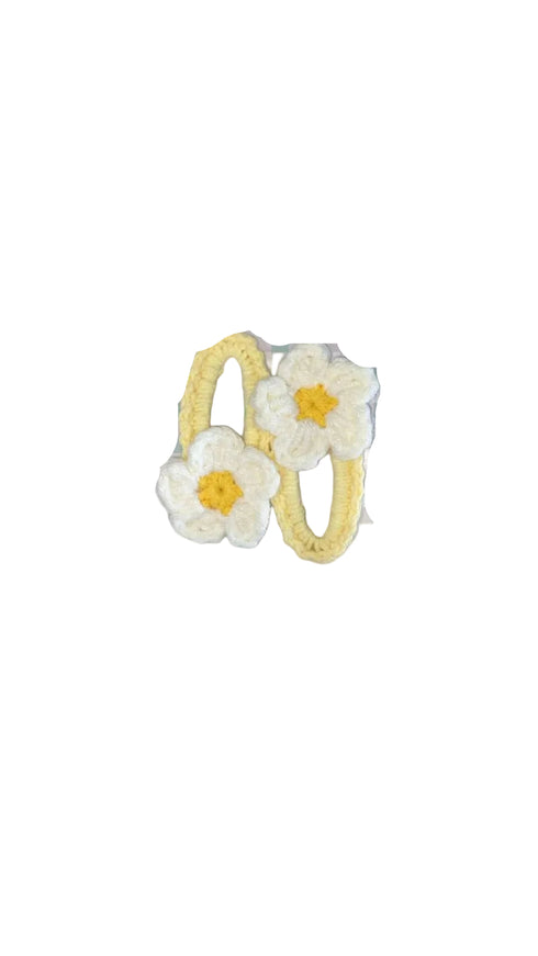 Pair of yellow hoop earrings with white floral accents on a white background